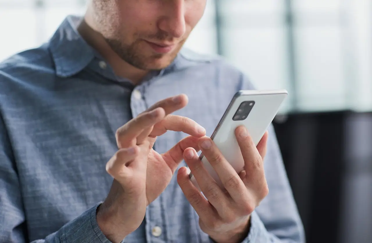 Un salarié utilise son smartphone pour gérer et faire fructifier son épargne.