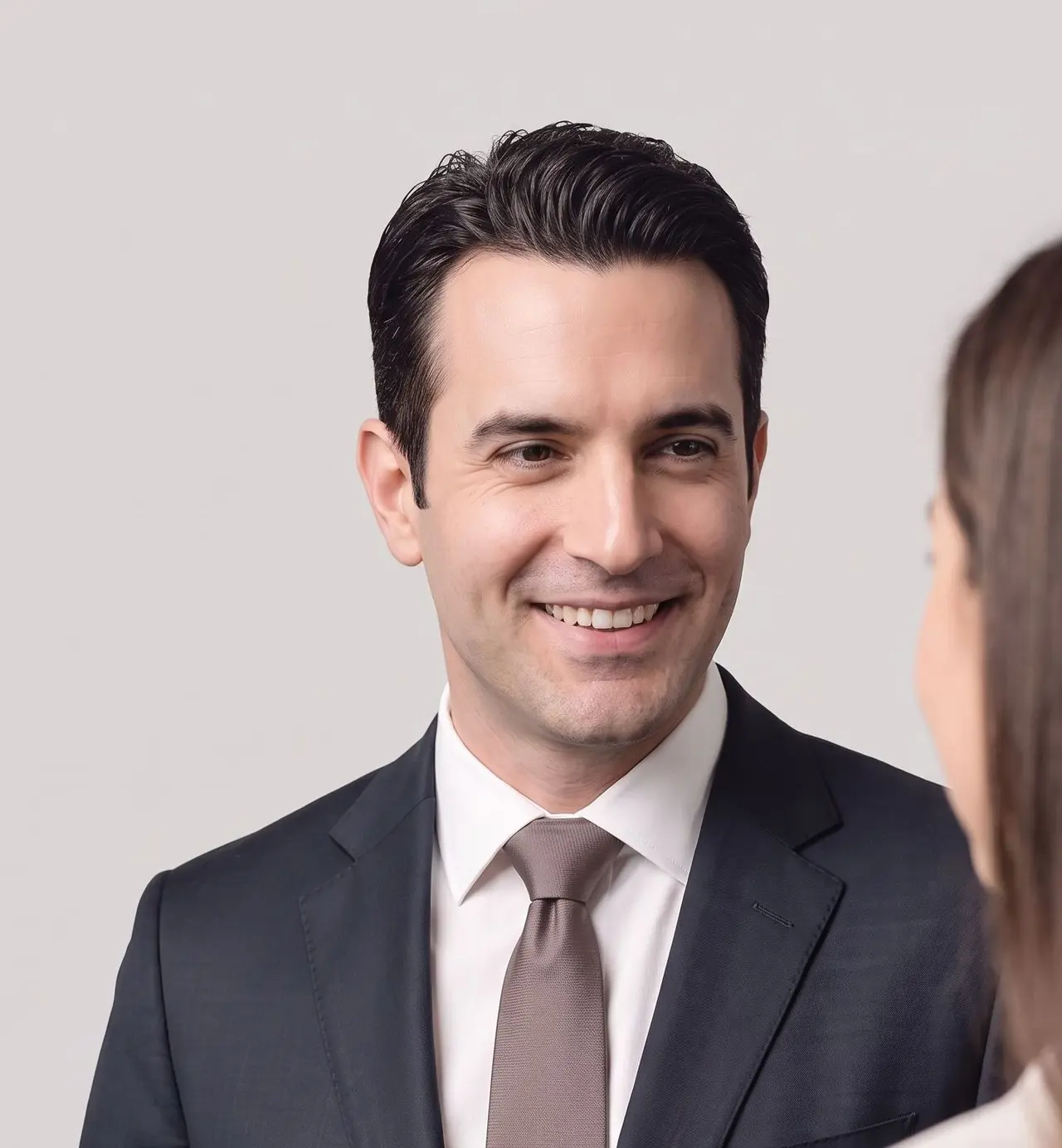Un professionnel en costume-cravate sourit chaleureusement lors d'un échange professionnel.