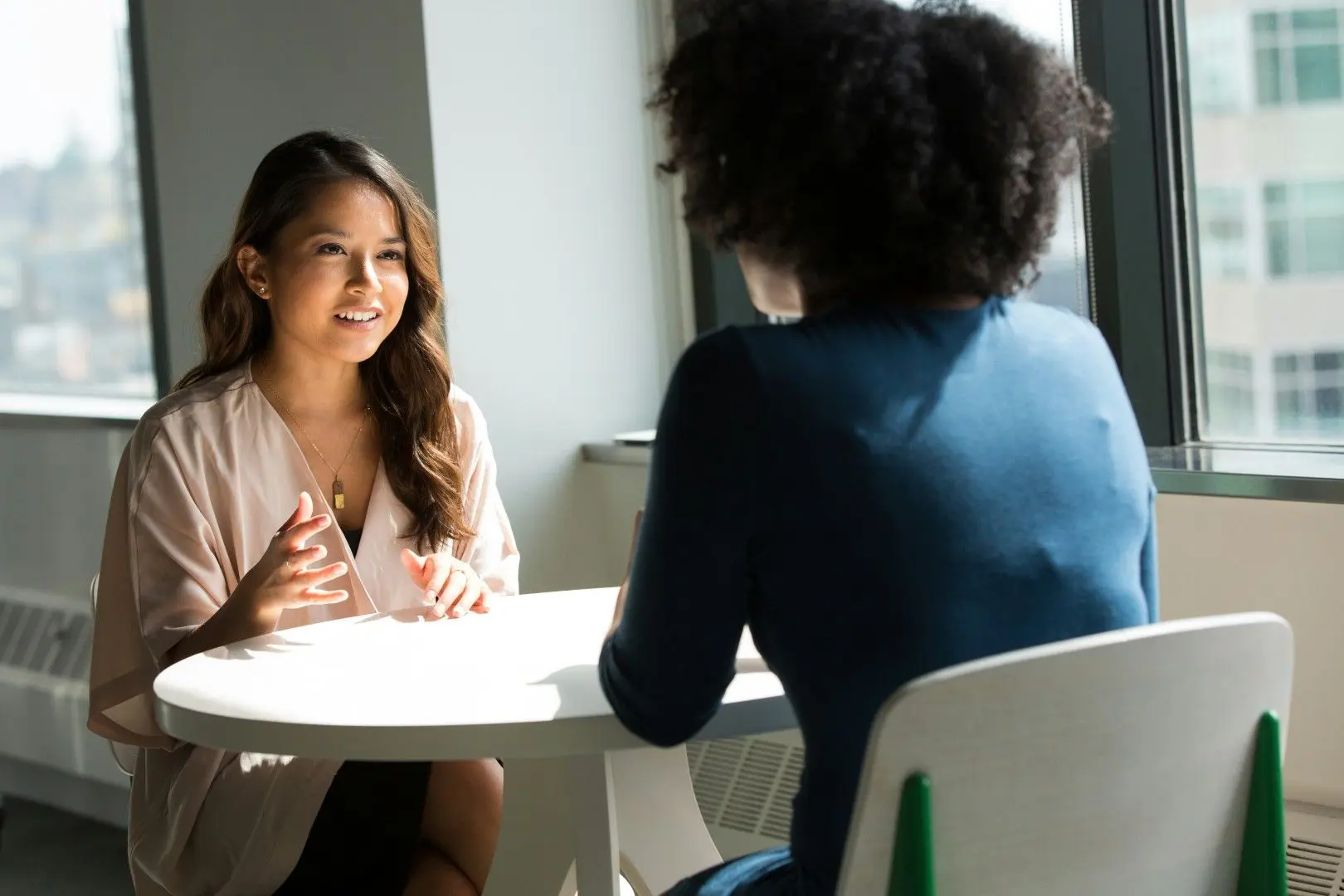 Une candidate et une recruteuse échangent au cours d'un entretien d'embauche dans un bureau.
