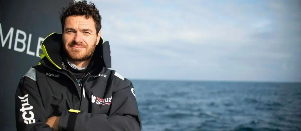 Anthony Marchand, skipper de l'Actual Ultim 3, pose en veste de mer devant l'océan.