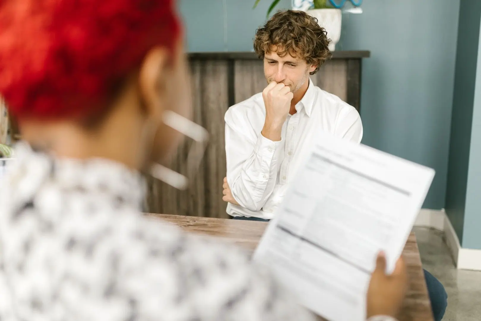 Un candidat inquiet en entretien d'embauche face à une recruteuse qui examine son CV.