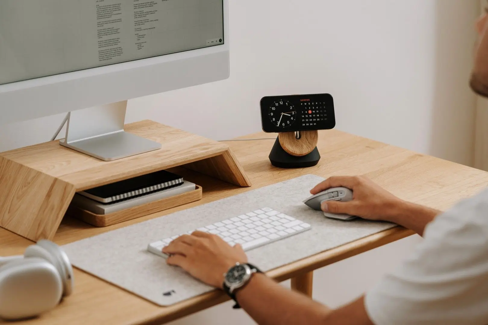 Un professionnel travaille sur son ordinateur dans un espace de télétravail organisé et ergonomique.