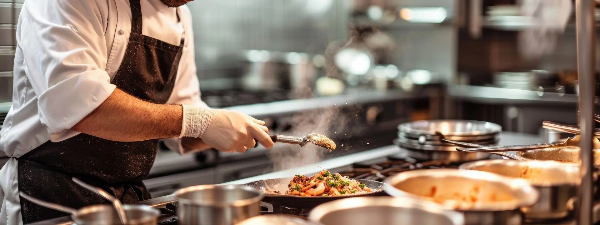 Un cuisinier prépare un plat chaud dans la cuisine professionnelle d'un restaurant.