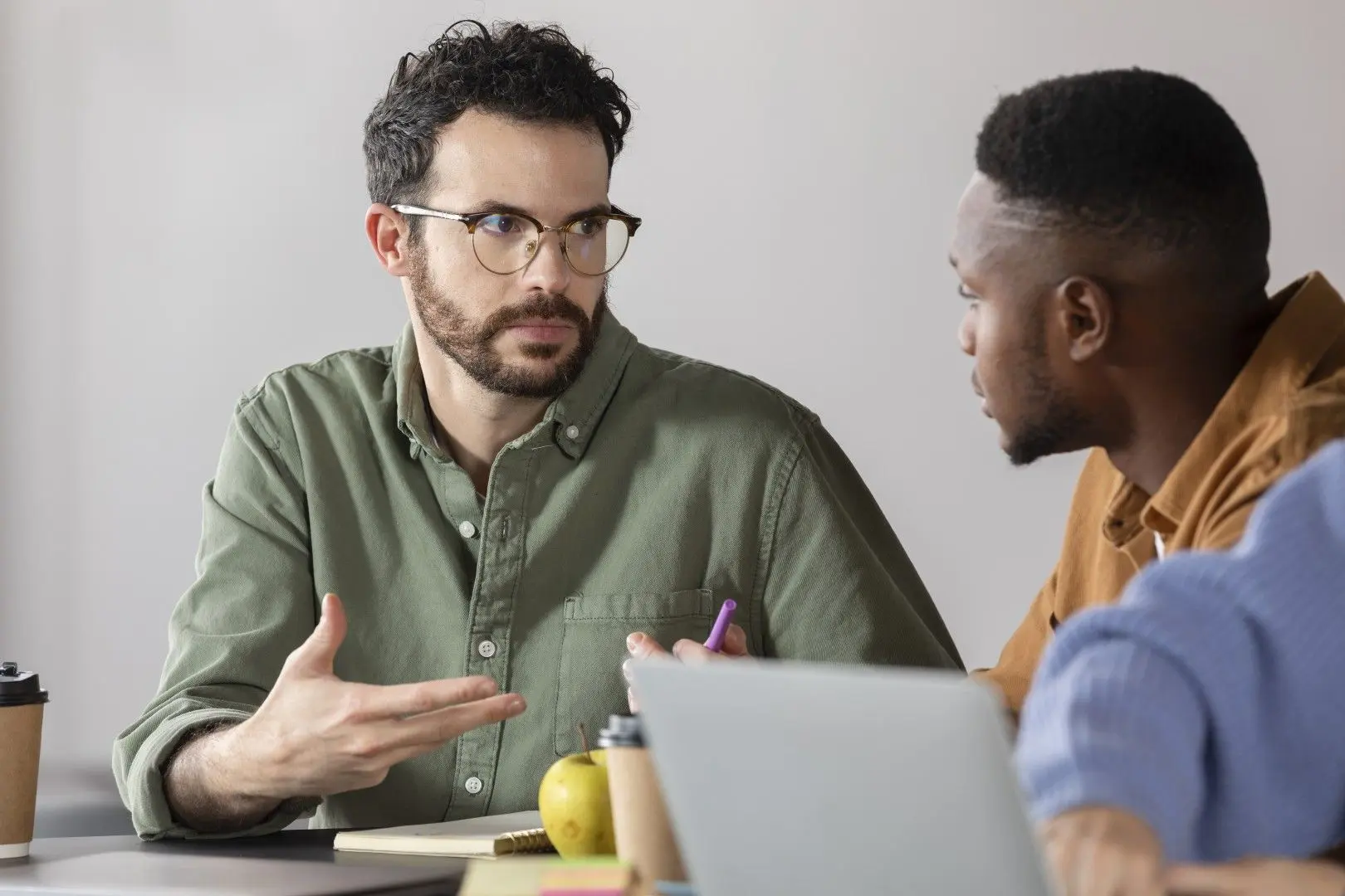Deux professionnels échangent au bureau lors d'un bilan de compétences.